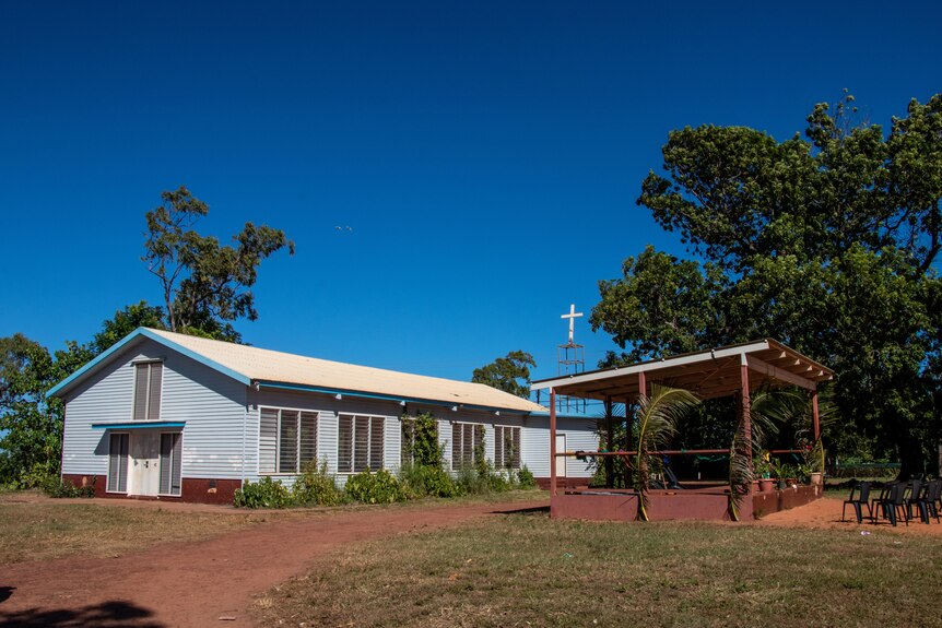 A church can be seen in a remote NT community. There is a stage with simple decorations.