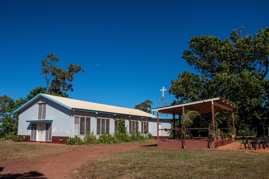 A church can be seen in a remote NT community. There is a stage with simple decorations.