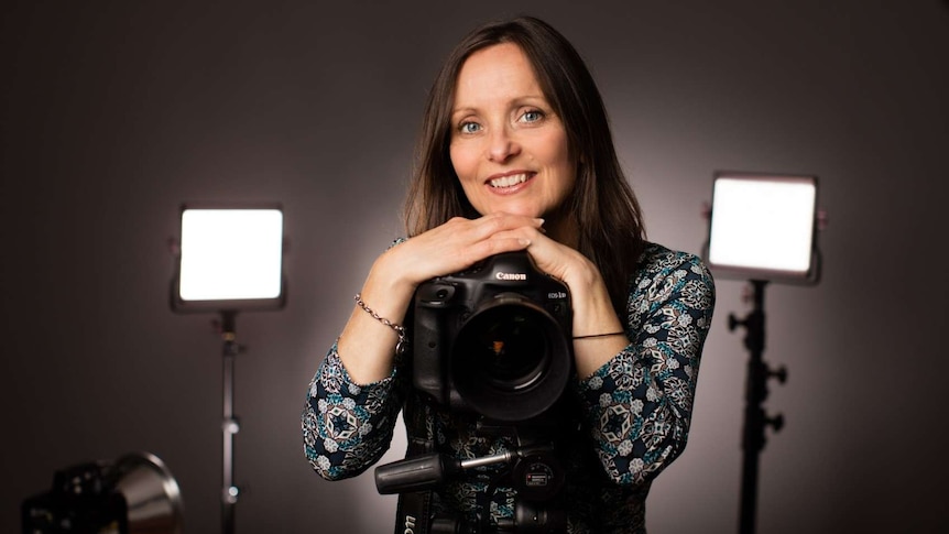 Nina posing in the studio with a camera