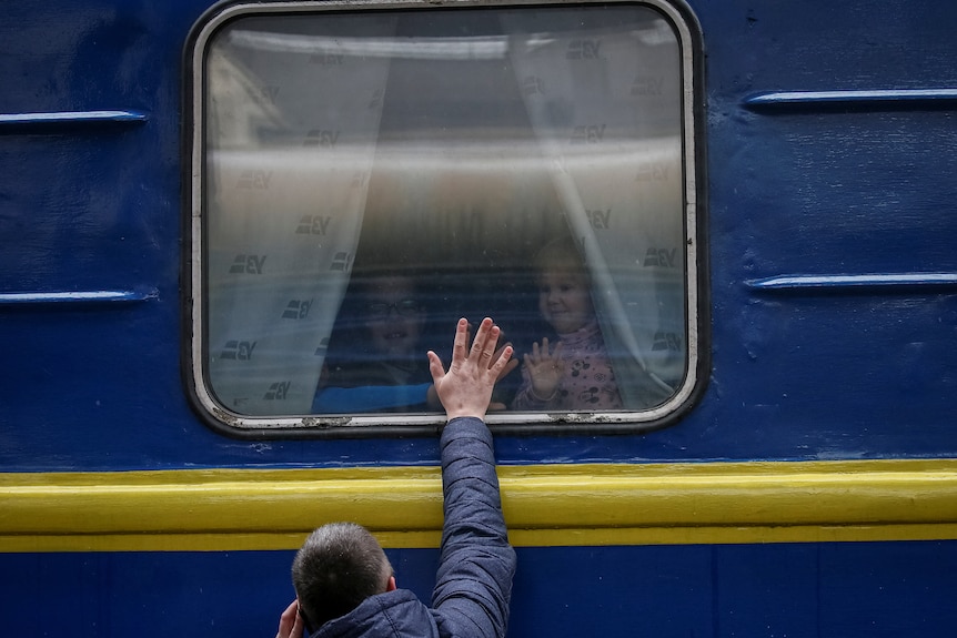 Children look out from an evacuation train from Kyiv to Lviv.