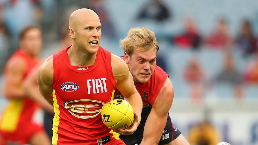 Ablett tries to beat the tackle of Watts