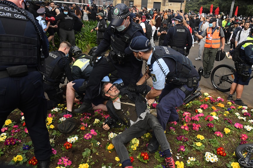 a man on the ground as police hover over him