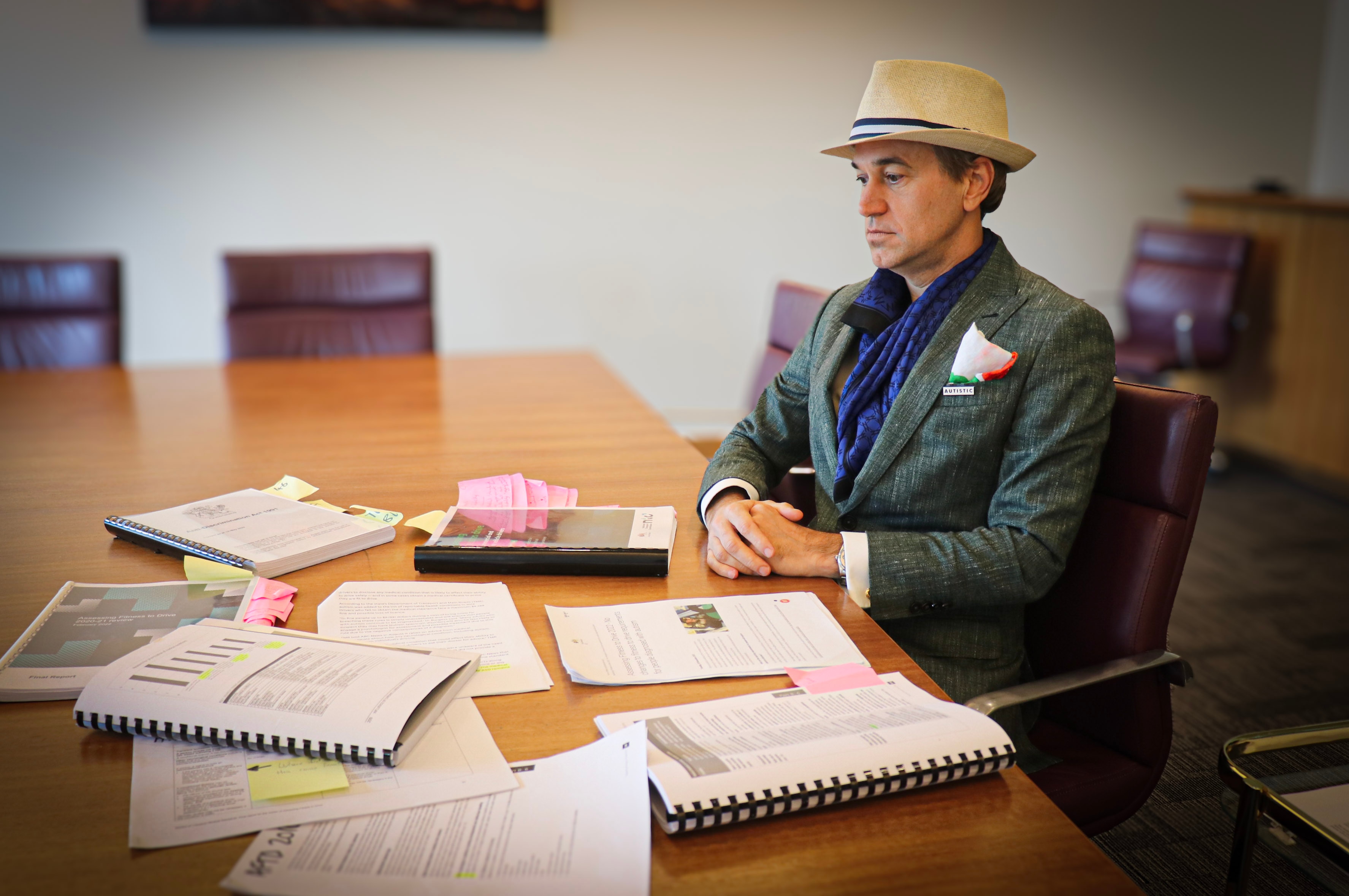 A man with a hat looking at documents on a table