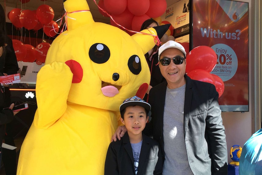 A man and boy pose with a large stuffed toy