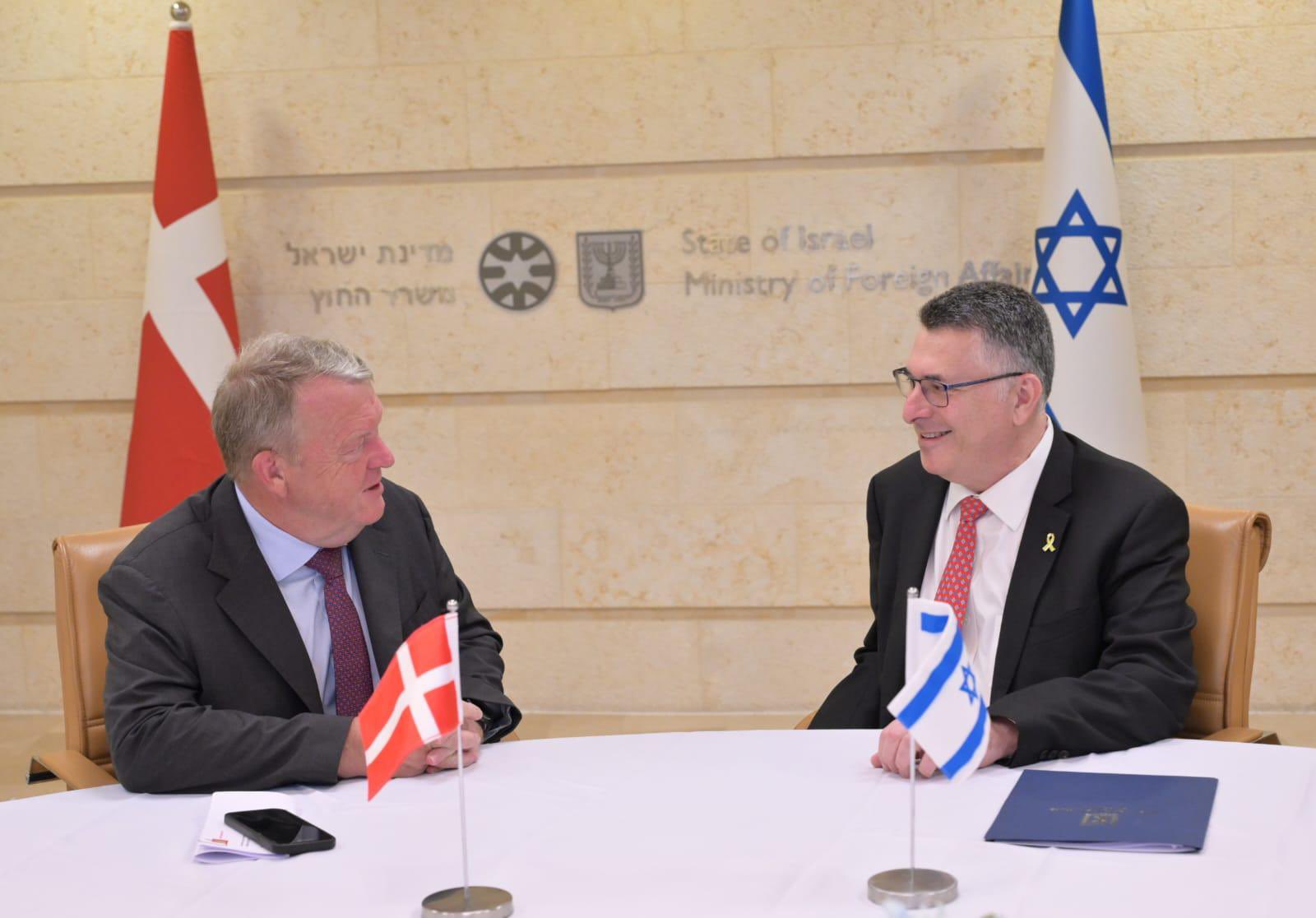 Two men sitting a table with the danish and Israeli flags