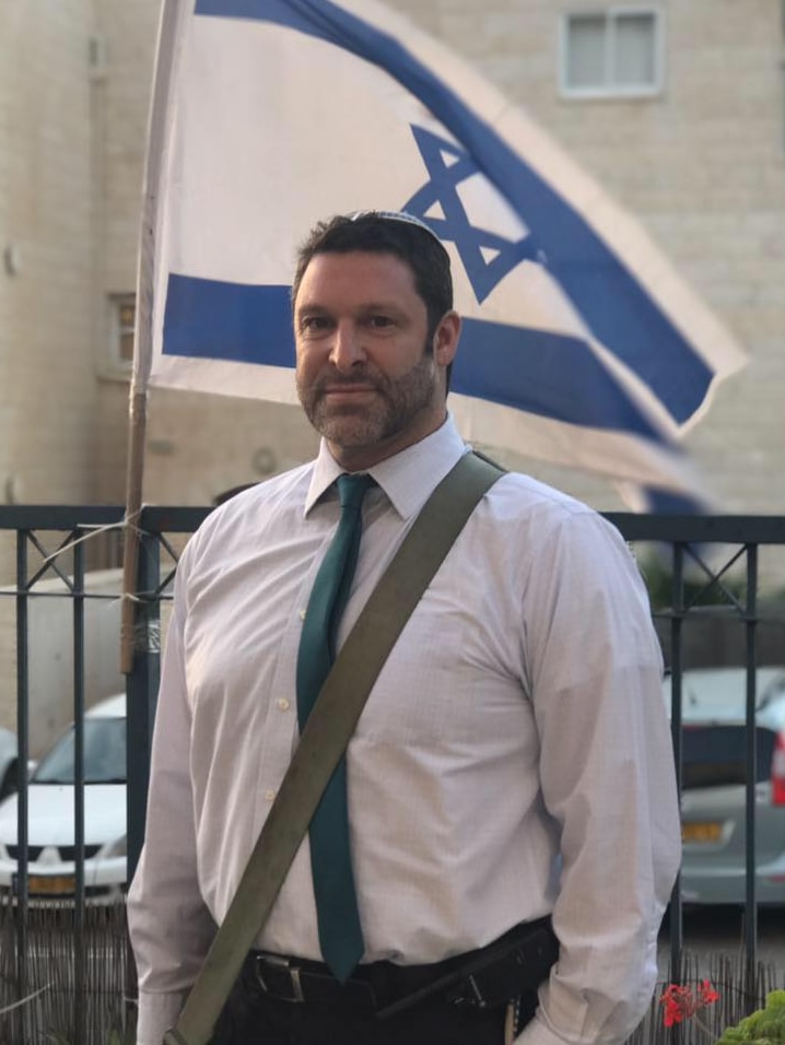 American-Israeli citizen Ari Fuld stands in front of an Israeli flag.