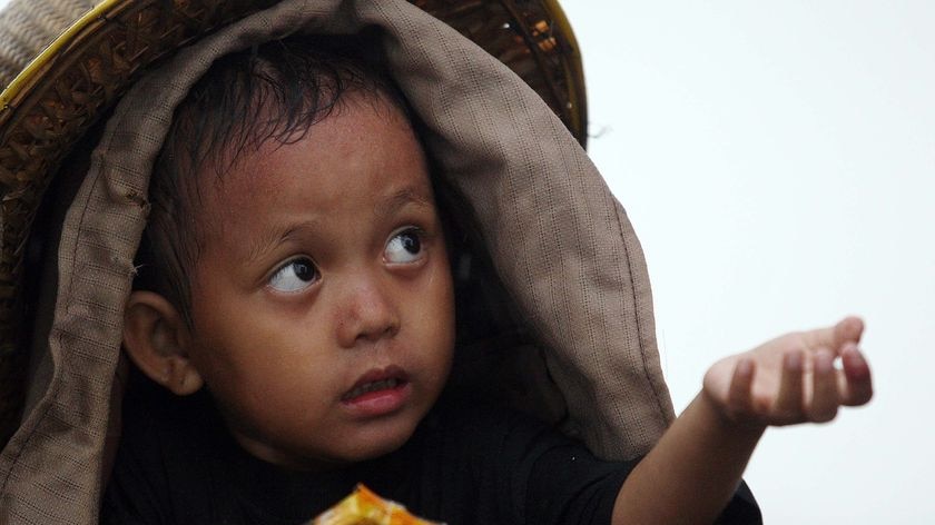 A Burmese child waits for more food in Dedaya, Burma