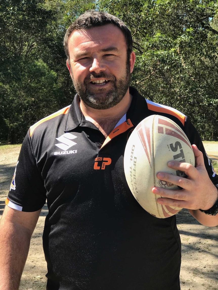 Lee Addison holding a rugby league ball.