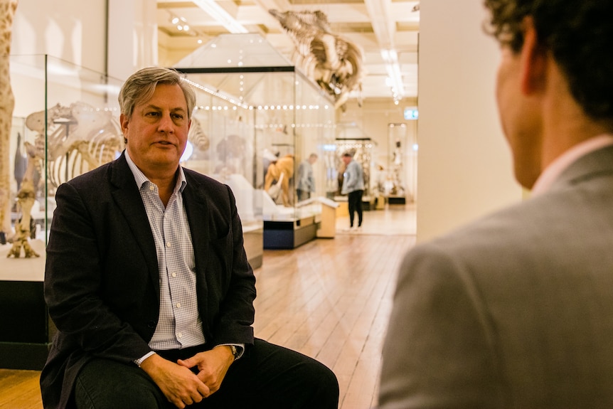 Man sits in museum opposite journalist.