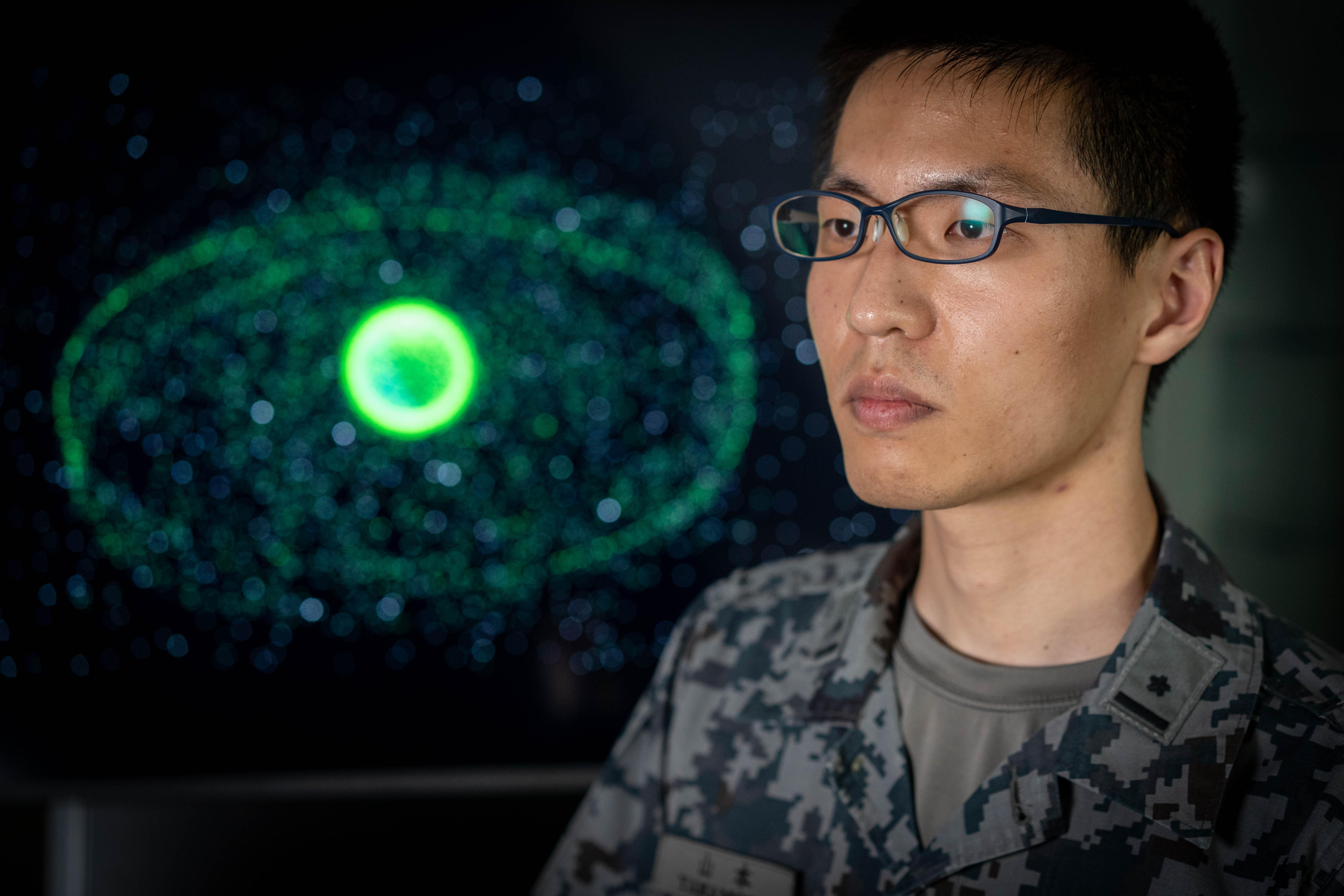A man looks to the side in front of a graphic of Earth surrounded by junk