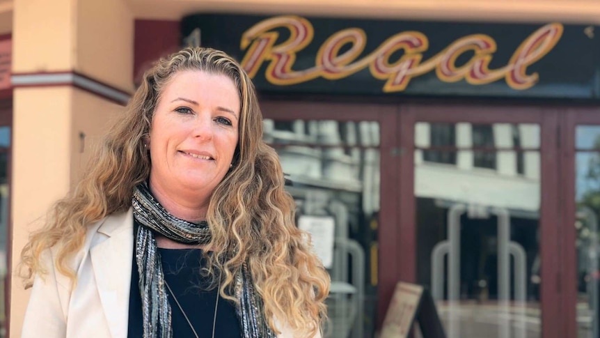 Kim Knight standing in street with the Regal Theatre sign in the background.