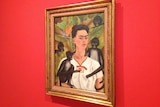 A framed portrait of Frida Kahlo in which she is surrounded by monkeys.