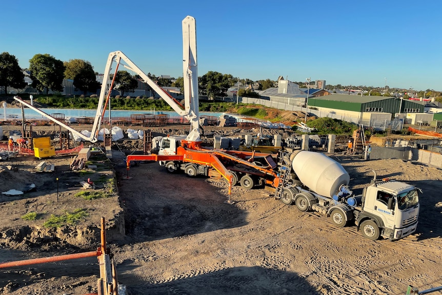 cranes and trucks excavating area of dirt