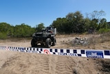 Police tape near a quad bike on a sandy track
