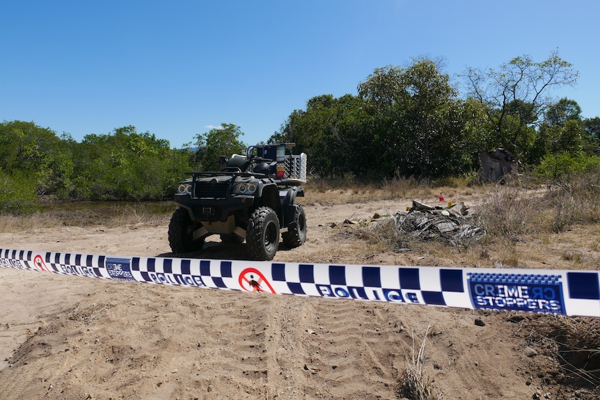 Police tape near a quad bike on a sandy track