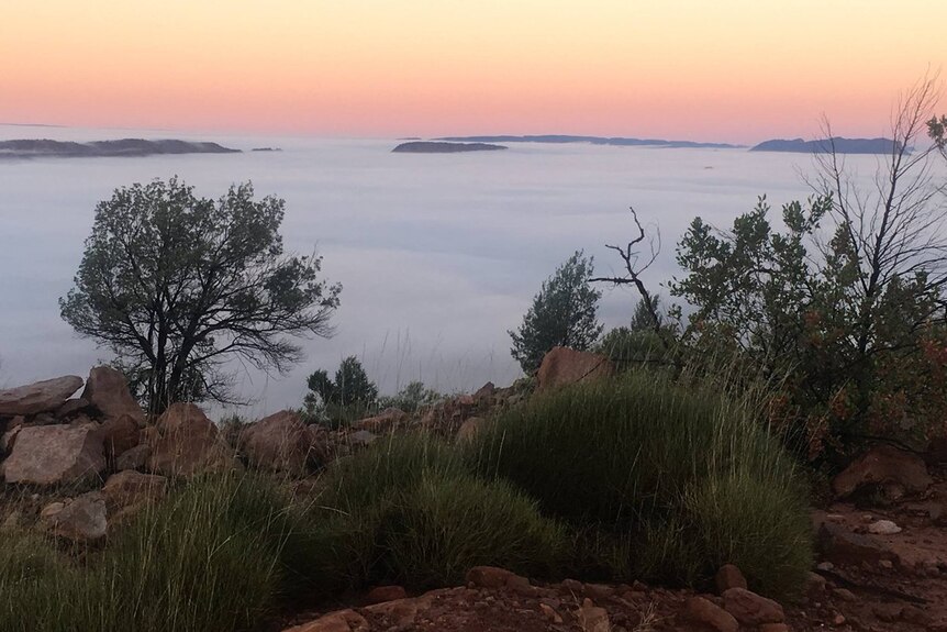 A blanket of fog across an escarpment at sunrise.