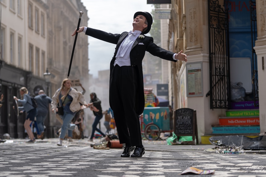 Man in top hat and tails dancing in the street.