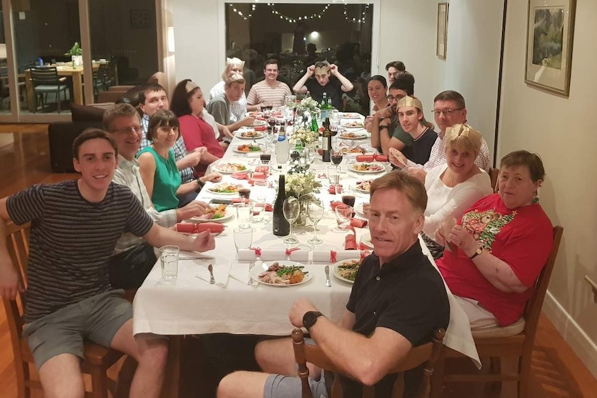 The Norman family gather at a long trestle table for Christmas lunch.