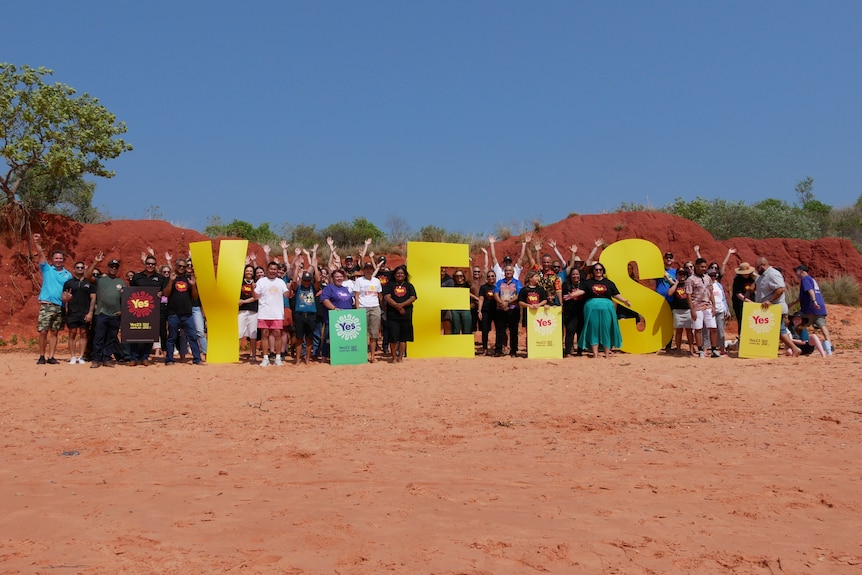 A group of around 50 people holding large letters 'Y', 'E' and 'S'.