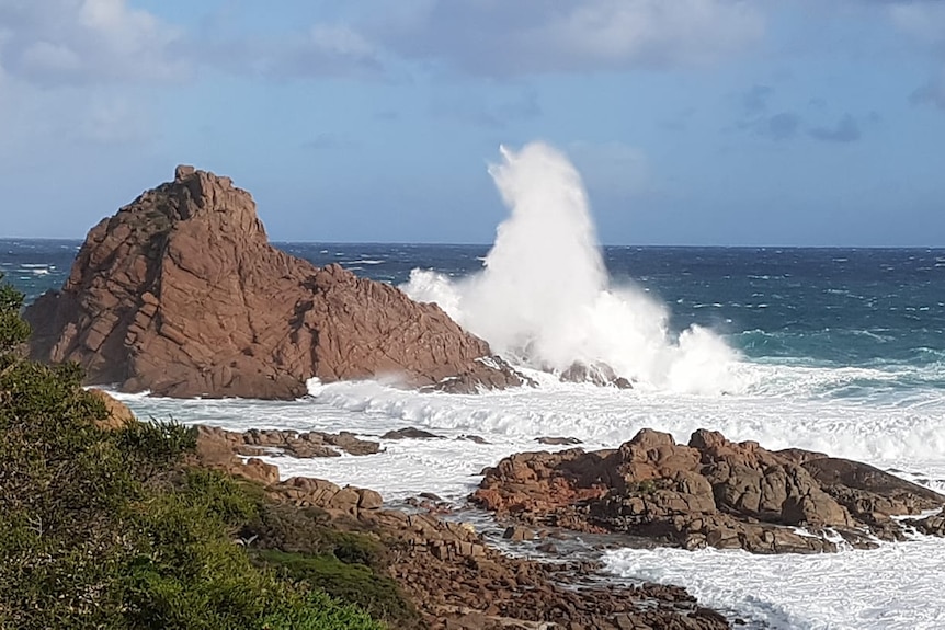 Waves crash into rock formations along the coast.