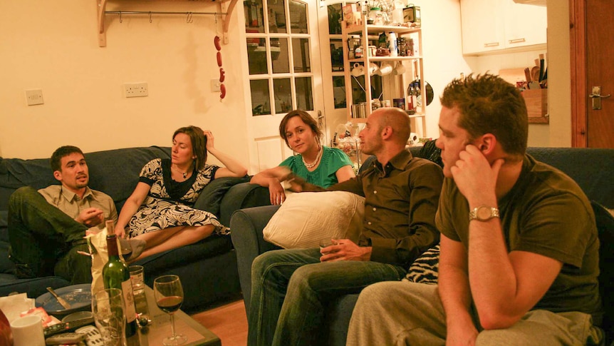 Five people sitting around a loungeroom table in a share house for a story about tips for preventing house fires