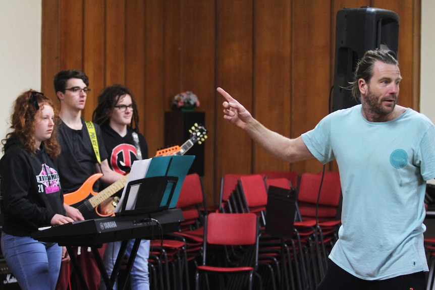 Man counting in a band of three young people