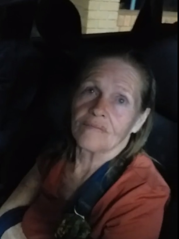 A still from a video of a woman strapped into the passenger seat of a car.