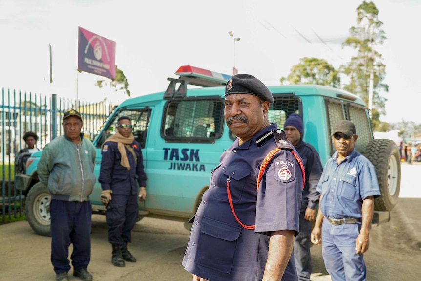 Chief Inspector Kamiak stands in front of a police vehicle while looking at the camera.