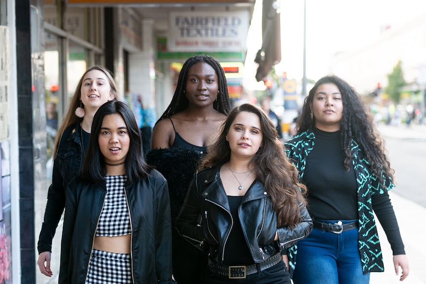 Mid-shot colour photograph of the all female cast of dance theatre work Playlist outside in the day walking down the street.