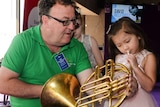 Little girl tries to play the French horn