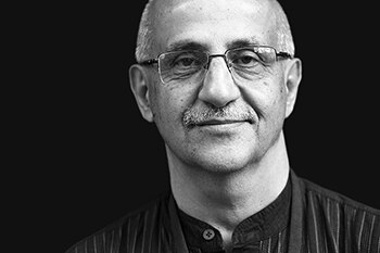 harsh mander smiling in a black and white headshot