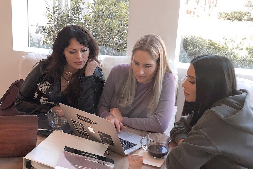 Kim Kardashian West sits with other students with law textbooks in front of her.