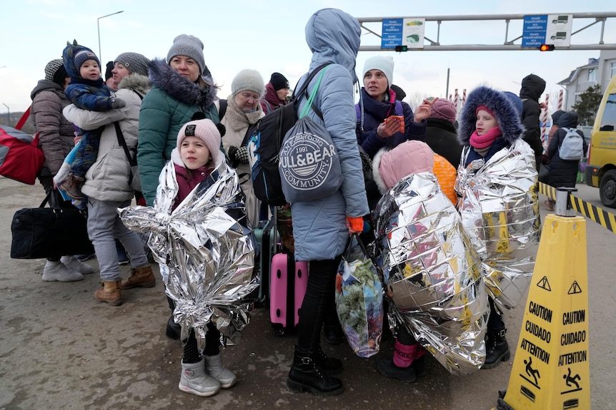 Refugees stand in a group after fleeing the war from neighbouring Ukraine 