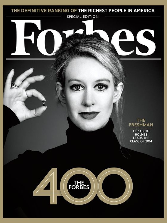 Elizabeth Holmes holds up a small vial of blood on a Forbes magazine cover.