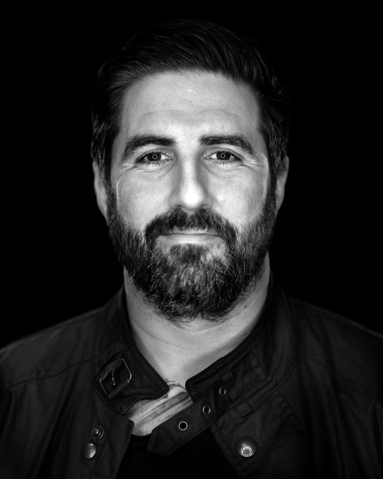 一张留着胡子的男人的黑白照片。