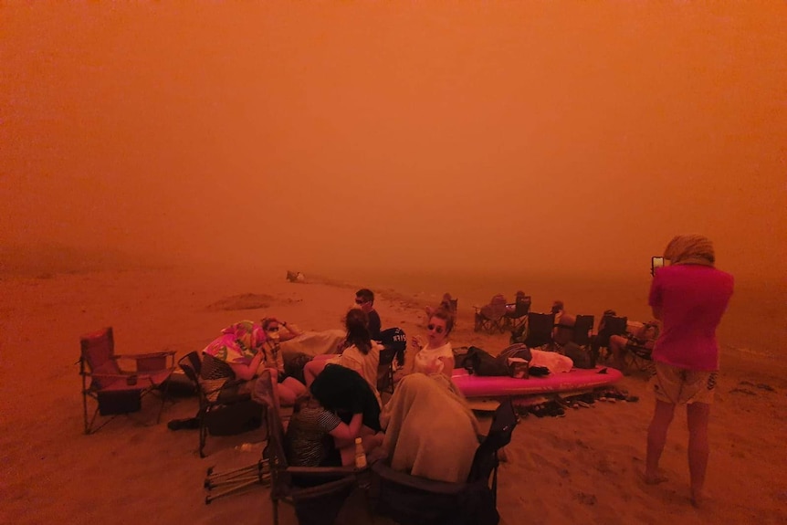 A red haze covers those evacuated on the beach at Bateman's Bay