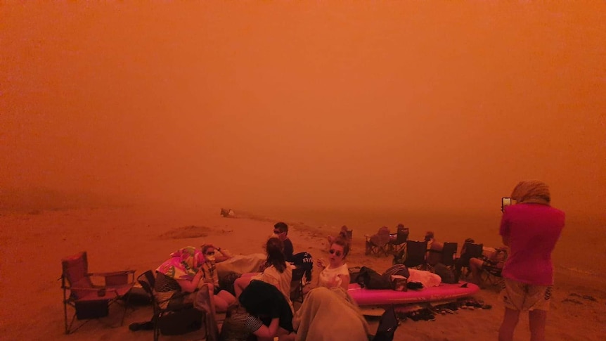A red haze covers those evacuated on the beach at Bateman's Bay
