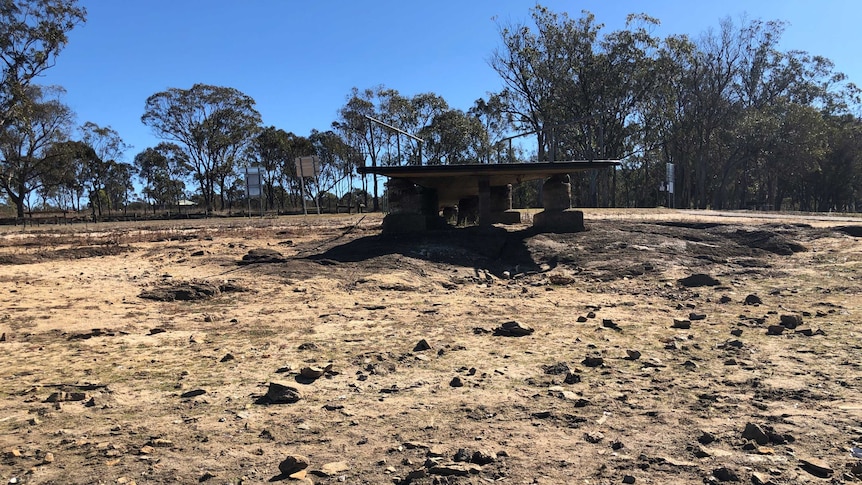 A jetty into a dry bed where town's water supply is meant to be.