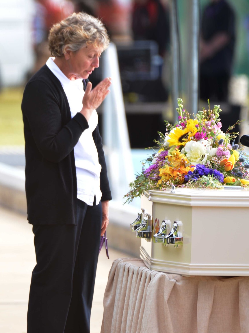 A mourner pays her respects near the casket of Kirsty Boden.