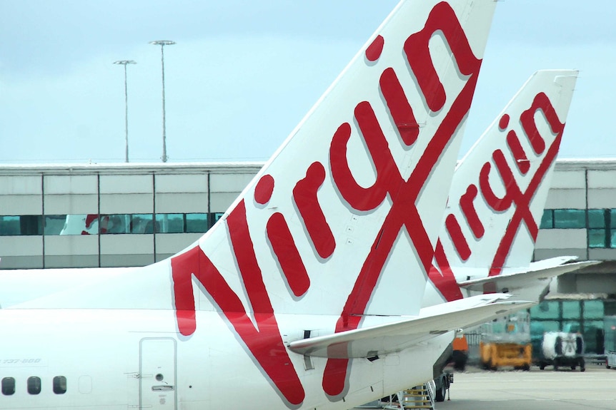 A close-up shot of two Virgin aircraft at an airport.