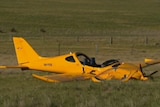 A crashed orange plane in a paddock