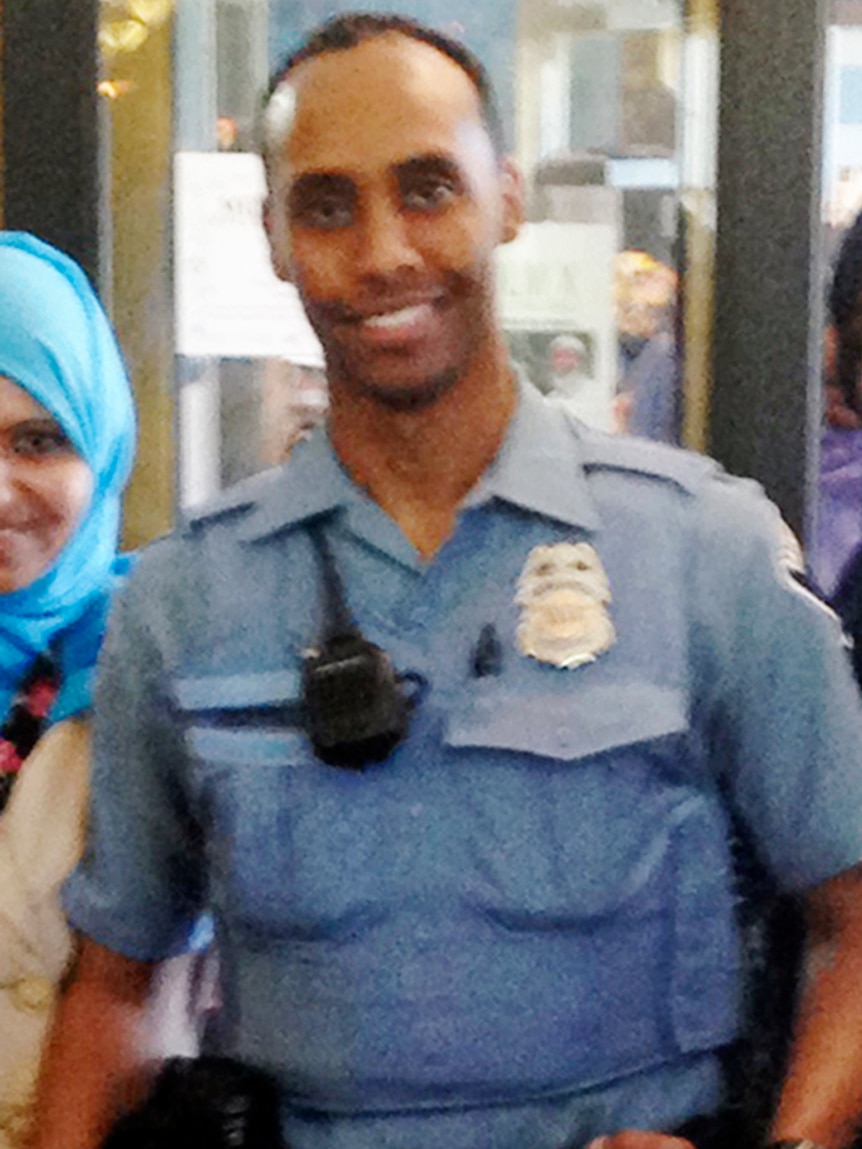 Police officer Mohamed Noor stands in uniform smiling into the camera.