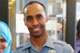 Police officer Mohamed Noor stands in uniform smiling into the camera.