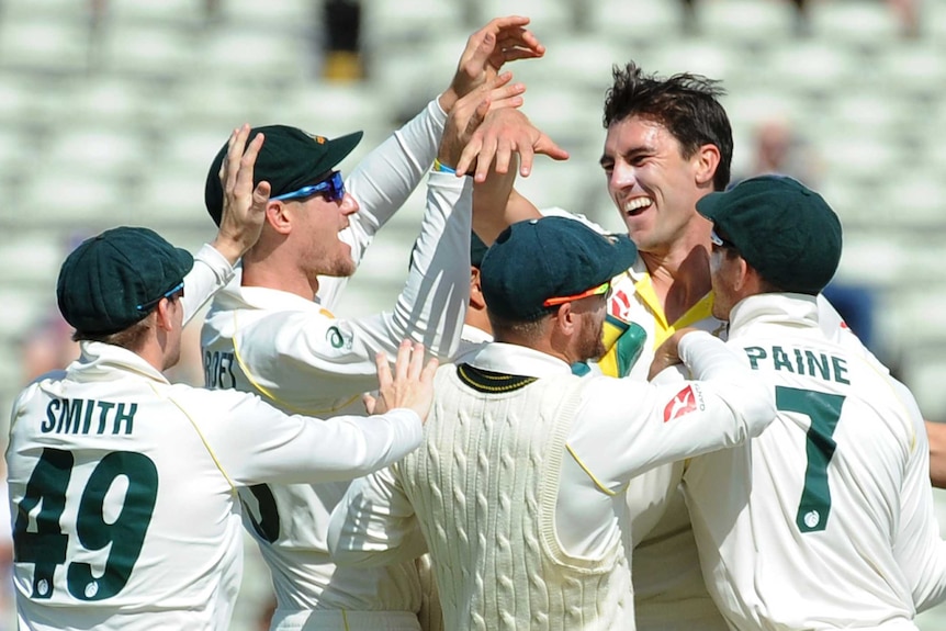 Pat Cummins is embraced by Australian Test teammates Steve Smith Cameron Bancroft, David Warner and Tim Paine.