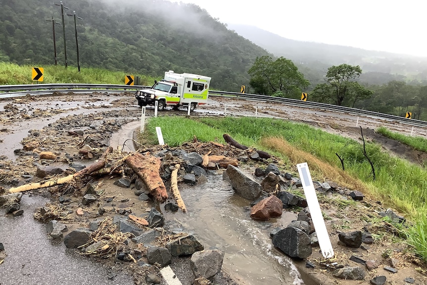 An ambulance on a steep road covered with rubble.