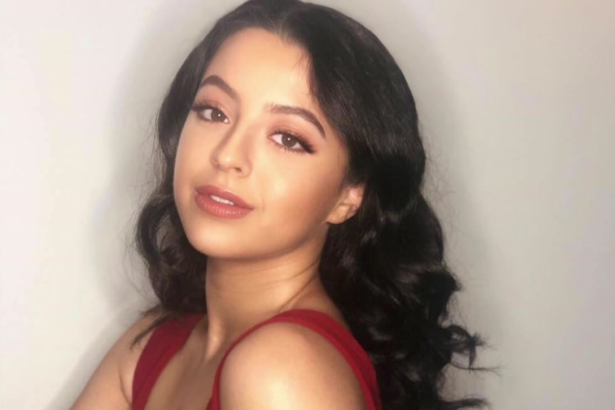 A young woman poses in a red dress