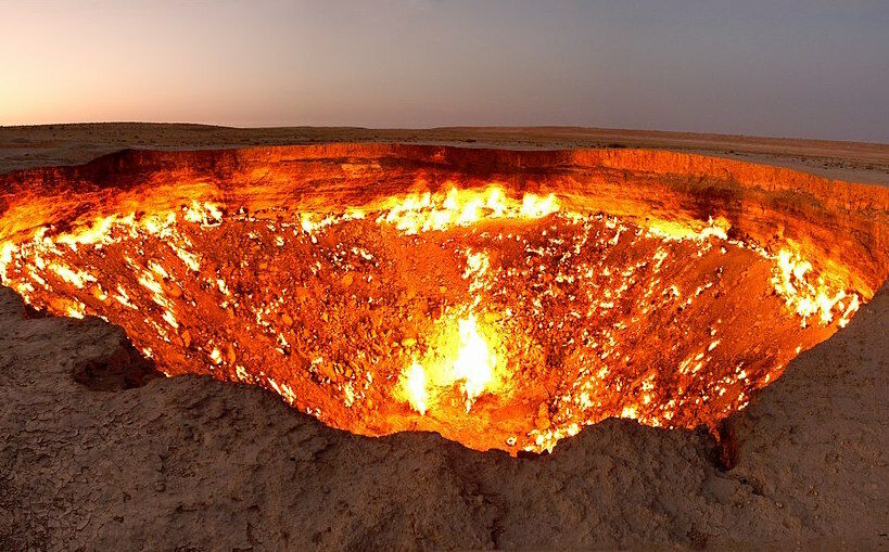A burning round crator lies in the middle of the desert.