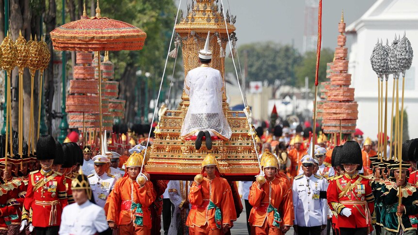 The Royal Urn of Thailand's late King Bhumibol Adulyadej being carried through a crowded street as part of procession.
