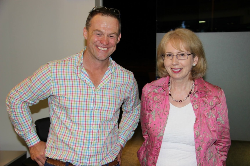 woman in pink shirt stands next to man in check shirt