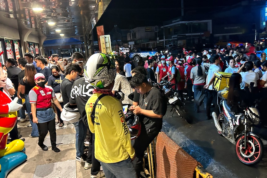 People gather in the street in Butuan City after an earthquake. 